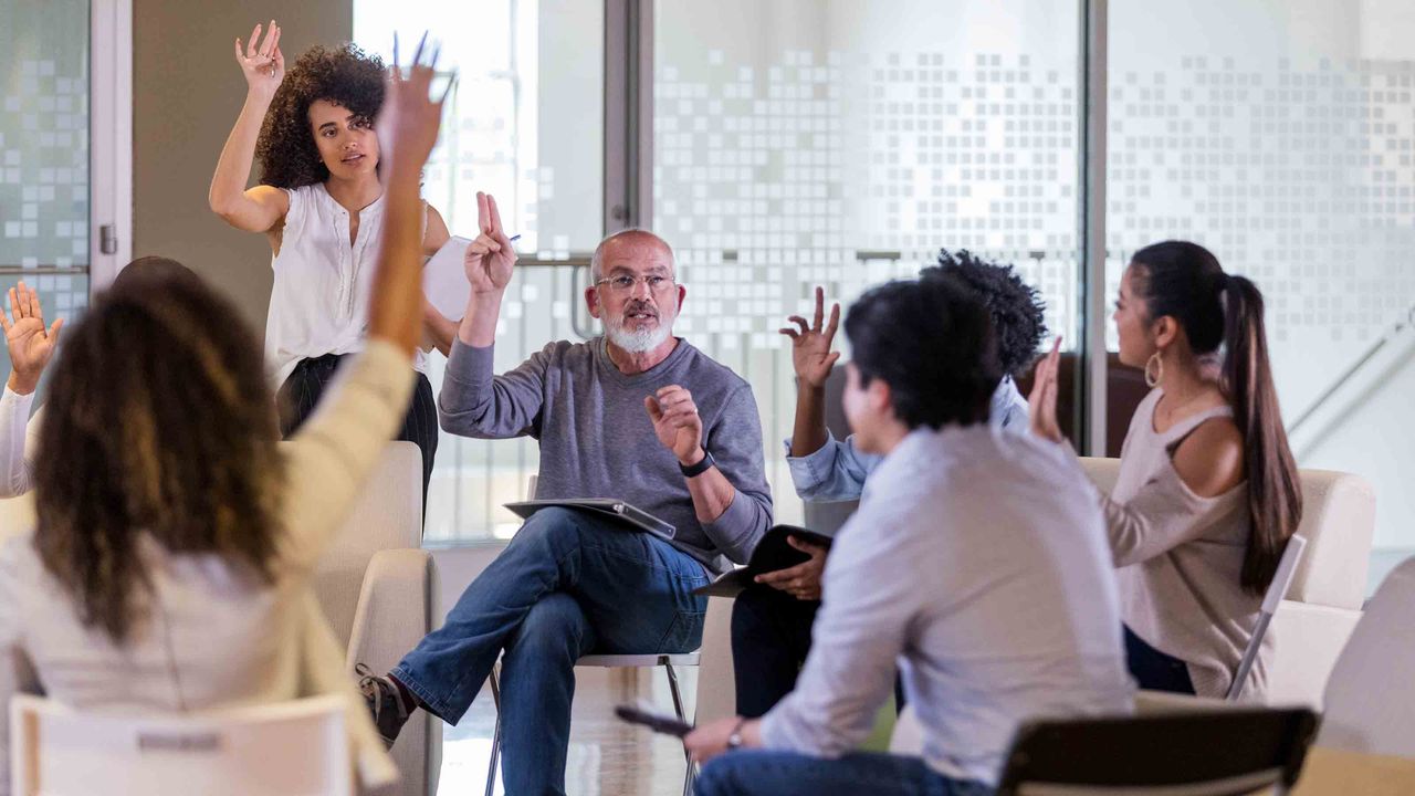 Mature male HOA president leads his neighbors in a vote during an HOA meeting.