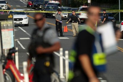 Police officers setting up perimeter at scene of shooting.