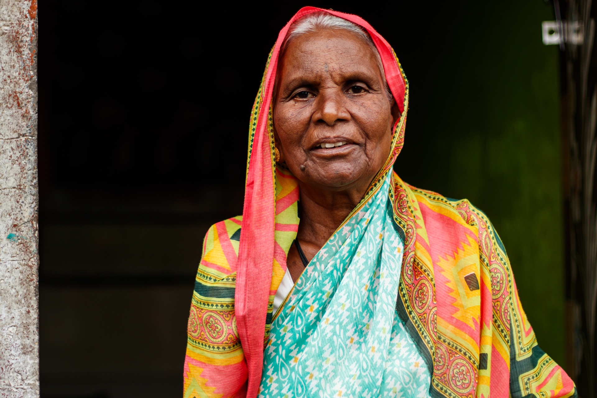 a close-up of an older Indian woman wearing traditional garments