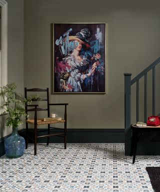 mosaic floor with green wall and black chair and staircase