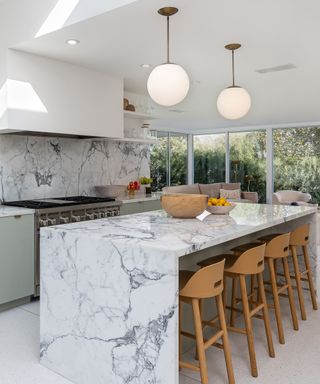 Mandy Moore's kitchen featuring a marble island, wood chairs, and spherical lights