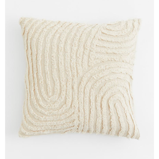 cream tufted pillow with curved line pattern