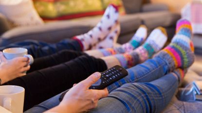 People with their feet up watching TV