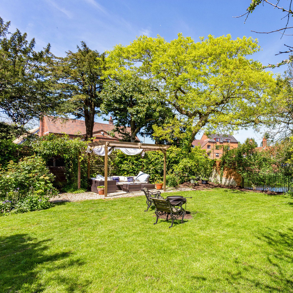 garden with green grass trees and buildings