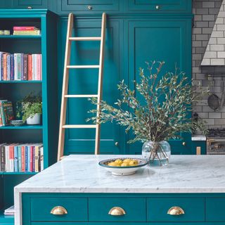 Green shaker kitchen with bookshelf and ladder