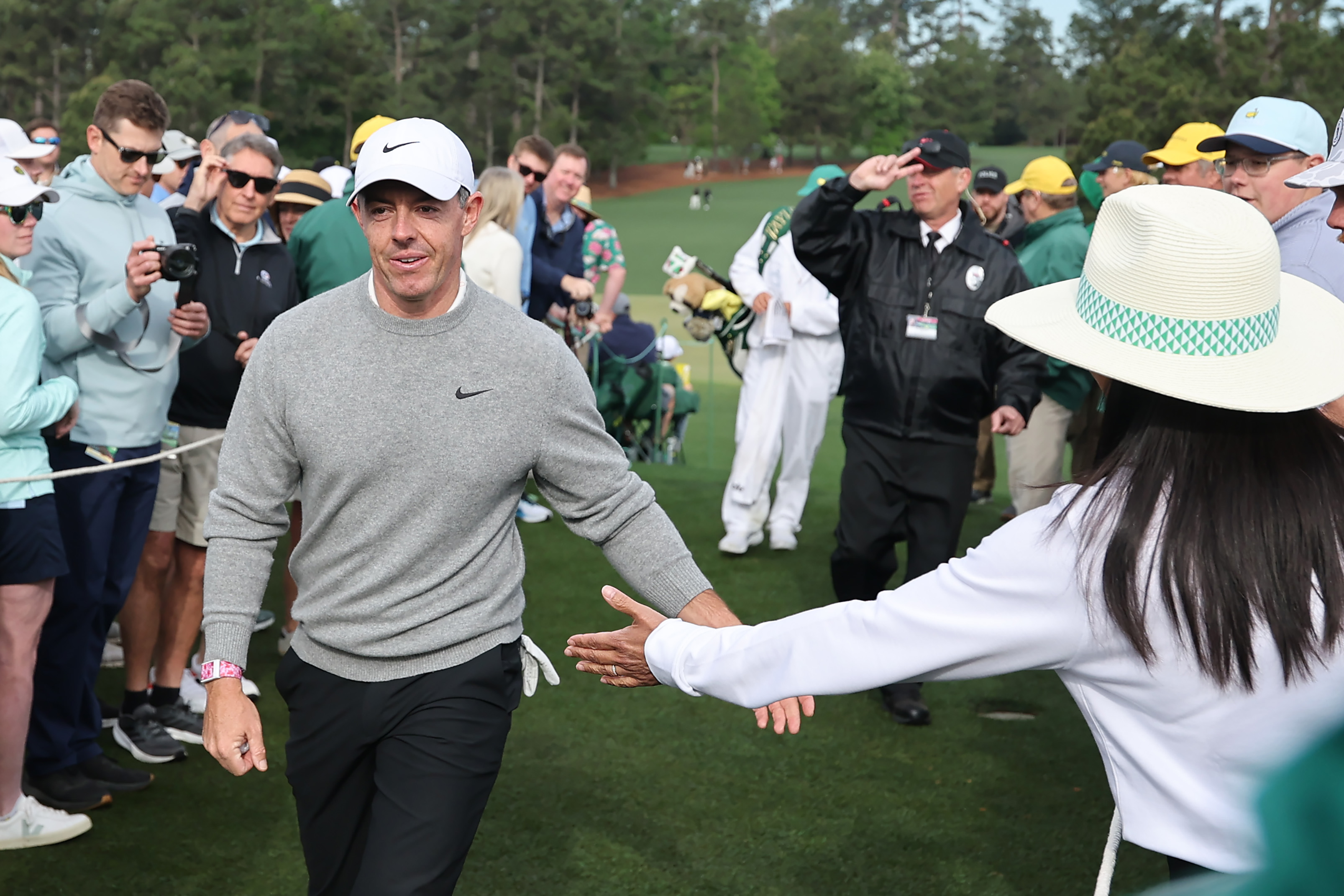 Rory McIlroy high-fives patrons as he walks to the 10th hole tee box during a practice round prior to the 2026 Masters Tournament at Augusta National Golf Club
