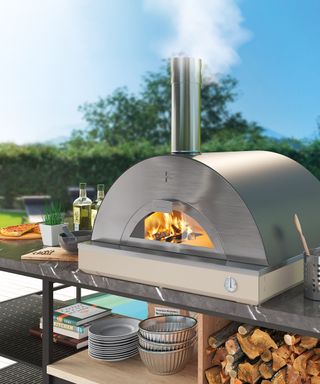 A stainless steel outdoor pizza oven next to a pool