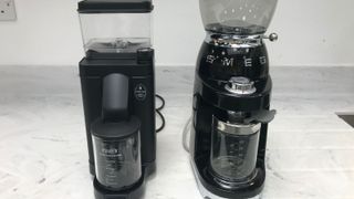 Moccamaster grinder beside the Smeg grinder, both in black