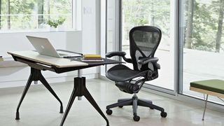 A black Aeron chair next to an office desk.