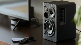 Black matted Bluetooth speakers on a desk 