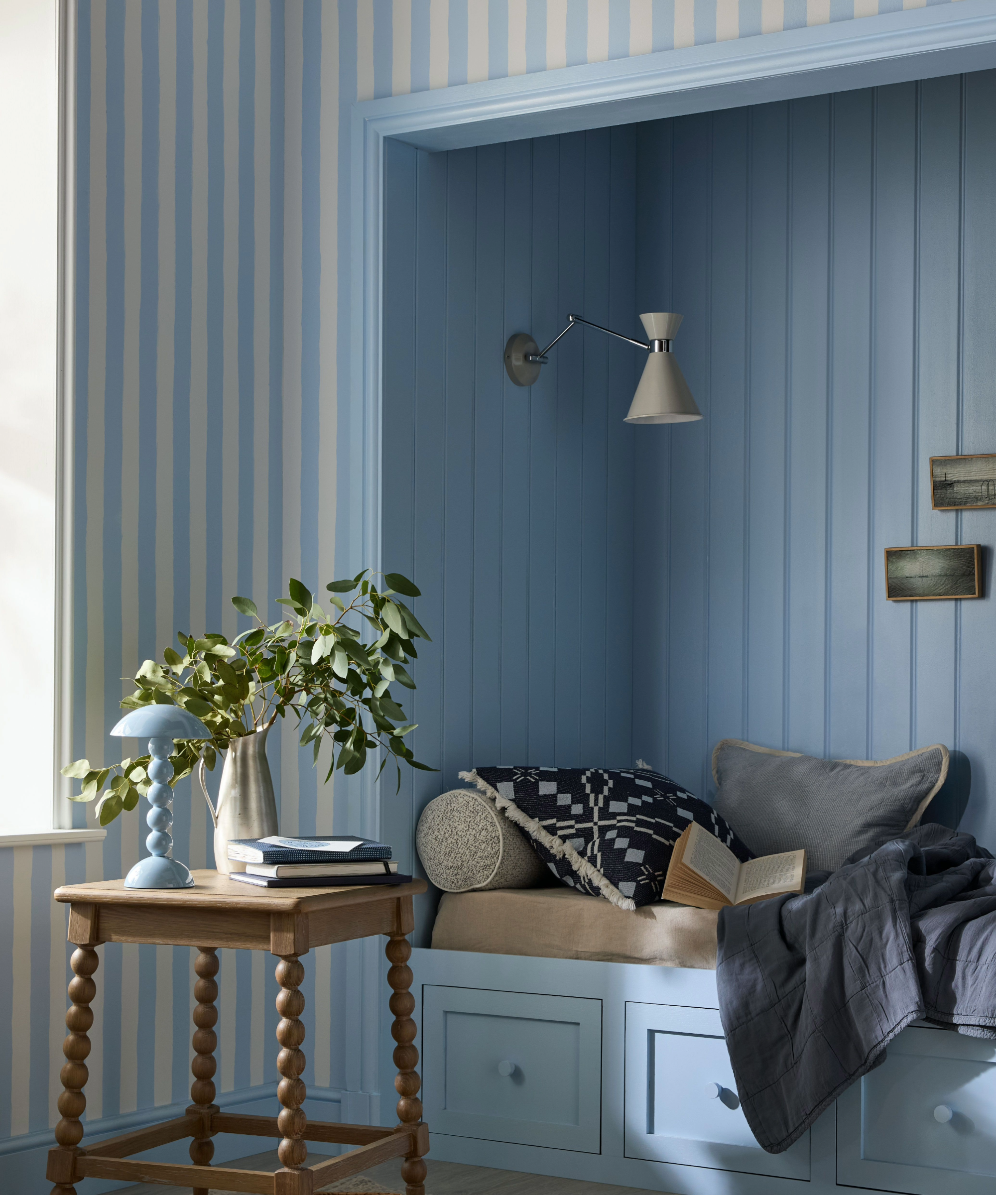 Reading nook with stripe wallpaper and blue paneling inside