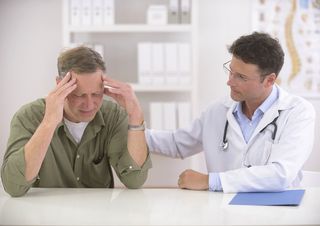 A middle age man talks with his doctor. 