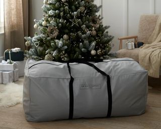The White Company Tree Storage Bag in grey in front of Christmas tree