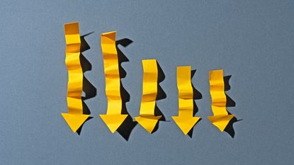 Five yellow paper arrows that are wrinkled and point down.