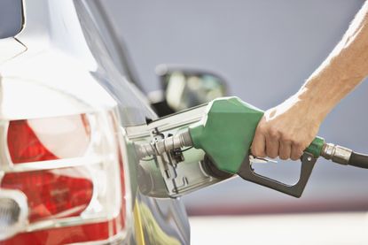 Man putting petrol in car at a fuel pump