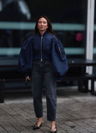 Stylish woman in London wearing a bomber jacket with oversized sleeves