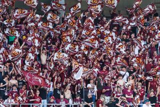 Torino fans wave flags during a derby against Juventus in April 2024.