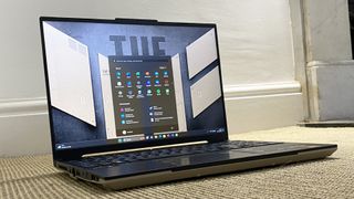 Asus TUF A16 laptop open on a beige rug