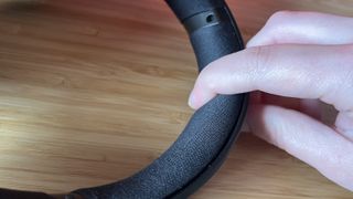 Hand pushing on padding on Asus ROG Delta II headband showing padding level