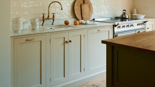 Cream shaker kitchen with marble worktops and brass range cooker