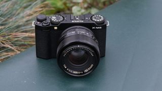 Fujifilm X-M5 camera with a Fujifilm 35mm lens attached on a green surface