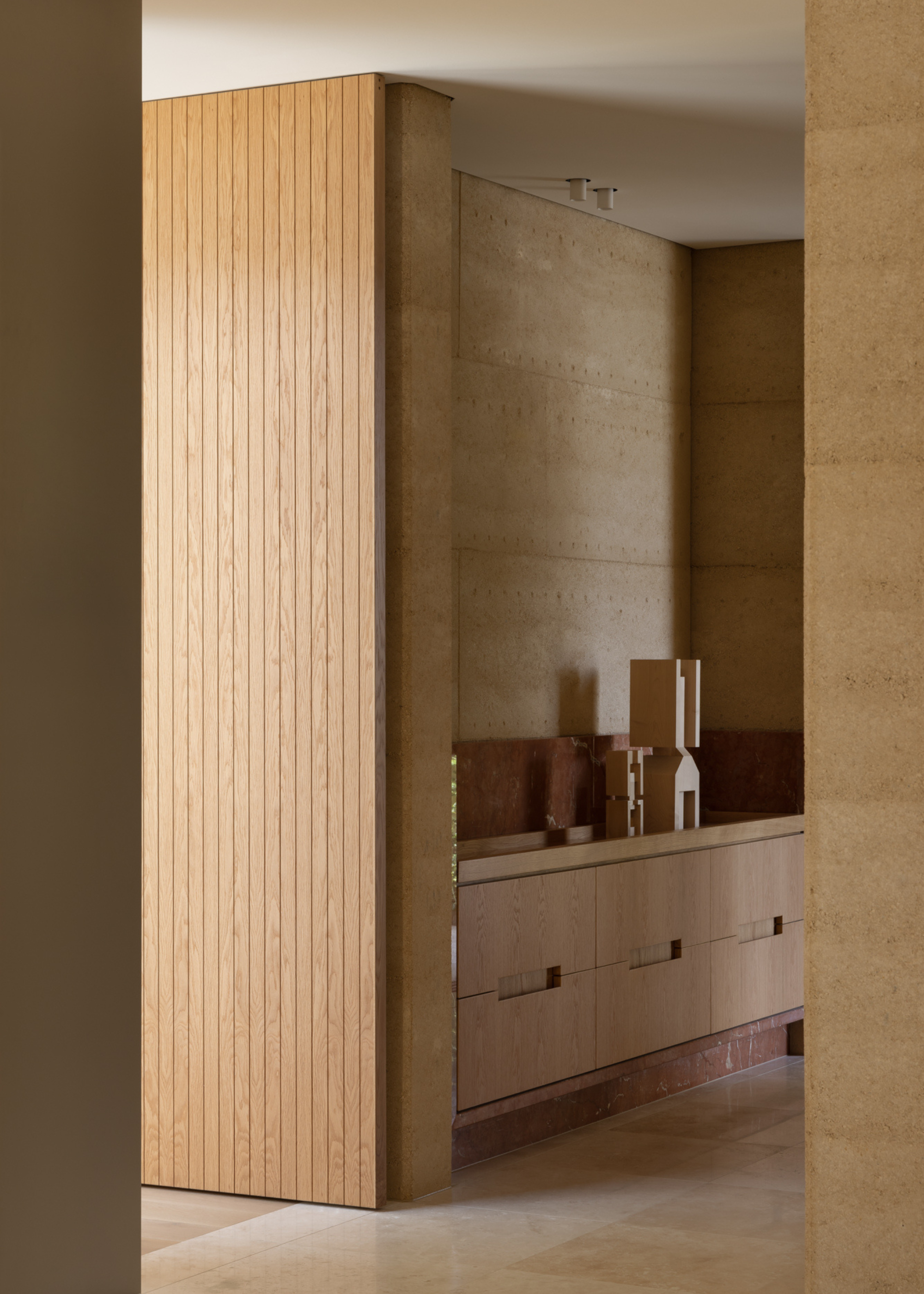 A minimalist wood entryway with a red marble base
