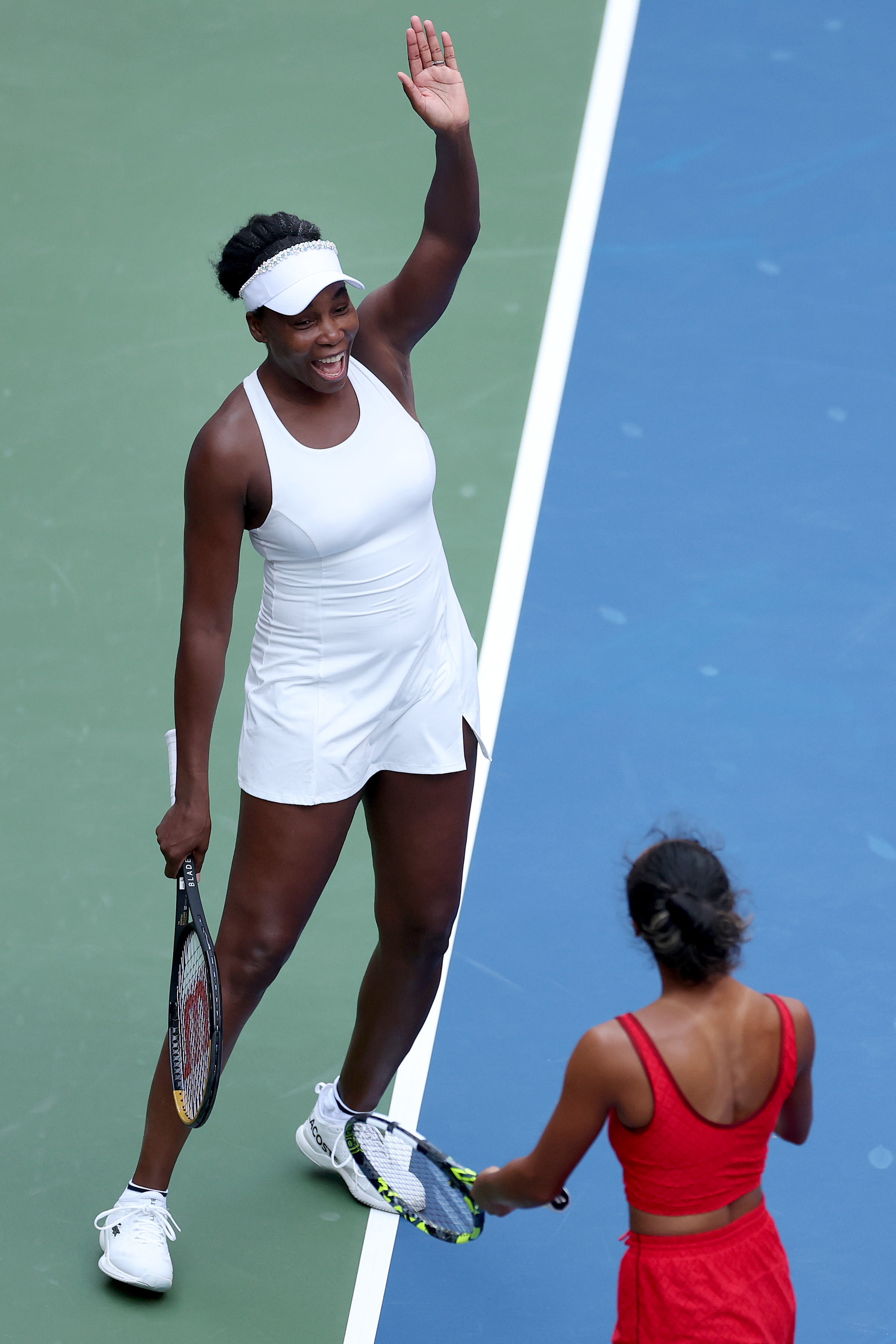 Venus Williams on the US Open court wearing a white dress with a visor