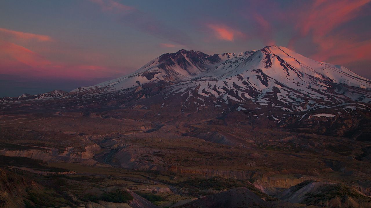 landscape image showing mount st. helens at sunset with pink clouds and the volcano covered in snow