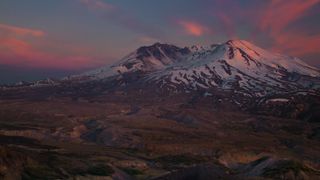 landscape image showing mount st. helens at sunset with pink clouds and the volcano covered in snow