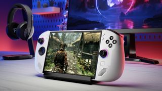 The Lenovo Legion Go S handheld gaming PC in white on a desk with headphones and a monitor