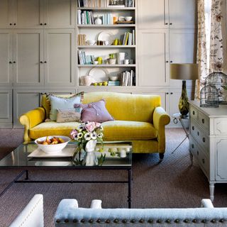 Beige living room with cabinetry and a yellow sofa