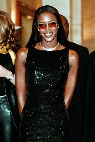 Naomi Campbell wears black dress, glasses and necklace
