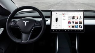 Steering wheel and central display inside the cabin of the Tesla Model 3