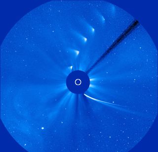 A timelapse photo of the sun showing a comet breaking apart as it goes past the sun