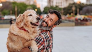 Man hugging his golden retriever on the streets of Buenos Aires