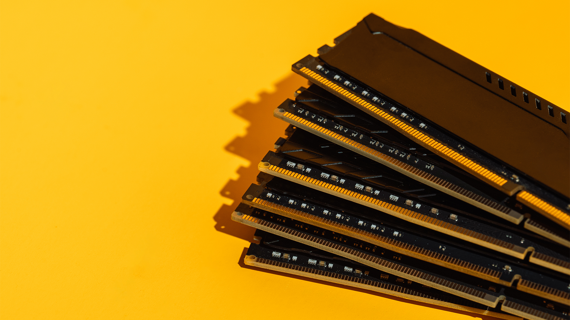 Stack of RAM sticks pictured against a yellow background.
