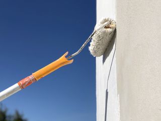 painting a house with a roller