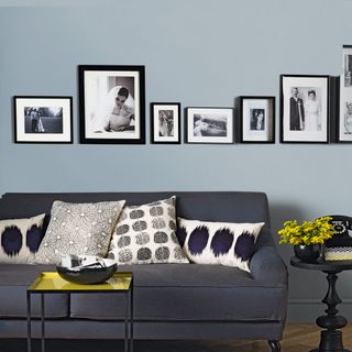 living area with blue wall and blue sofa and picture frames