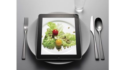 ipad with plate, silver ware, and water