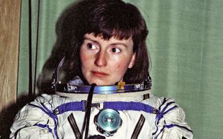 Helen sharman sitting in a spacesuit and looking to her right.