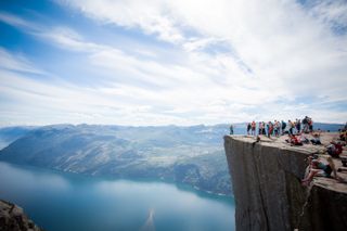 Tourists stand on Preikestolen to see Lysefjord