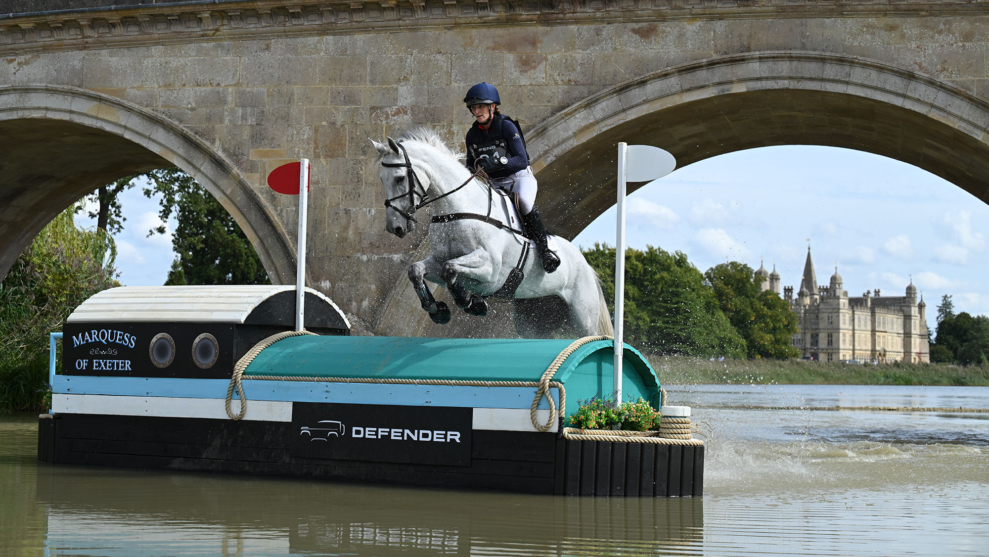 Holly Richardson and Ballyneety Silver Service jump a fence in water on the cross-country at Burghley Horse Trials 2025.