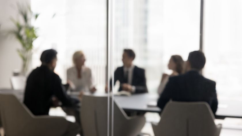 Group of businesspeople negotiating gathered in modern conference room, blurred silhouettes view, meeting behind closed glass doors. Business communication, workflow, decision-making, strategy sharing