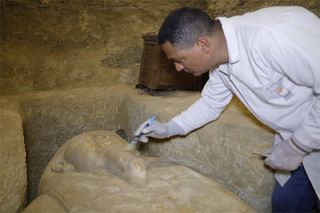 Conservation work being done on the head of one of the stone sarcophagi that was discovered.