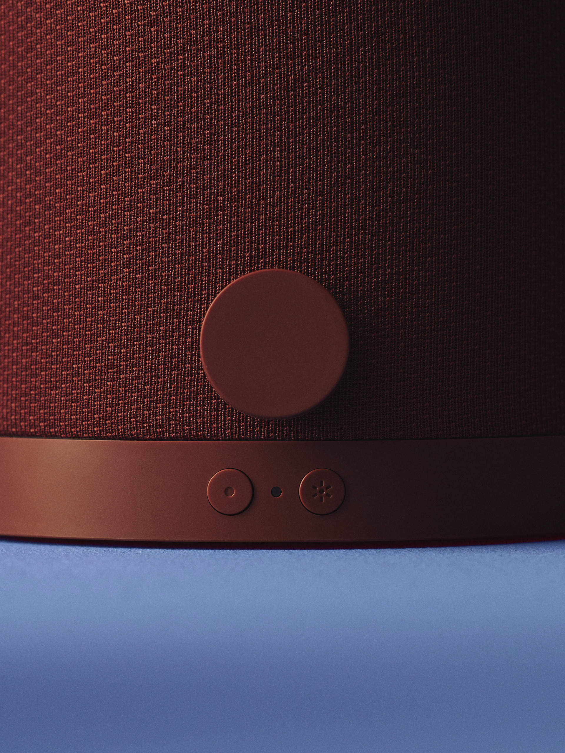 close up of burgundy speaker controls on blue backdrop