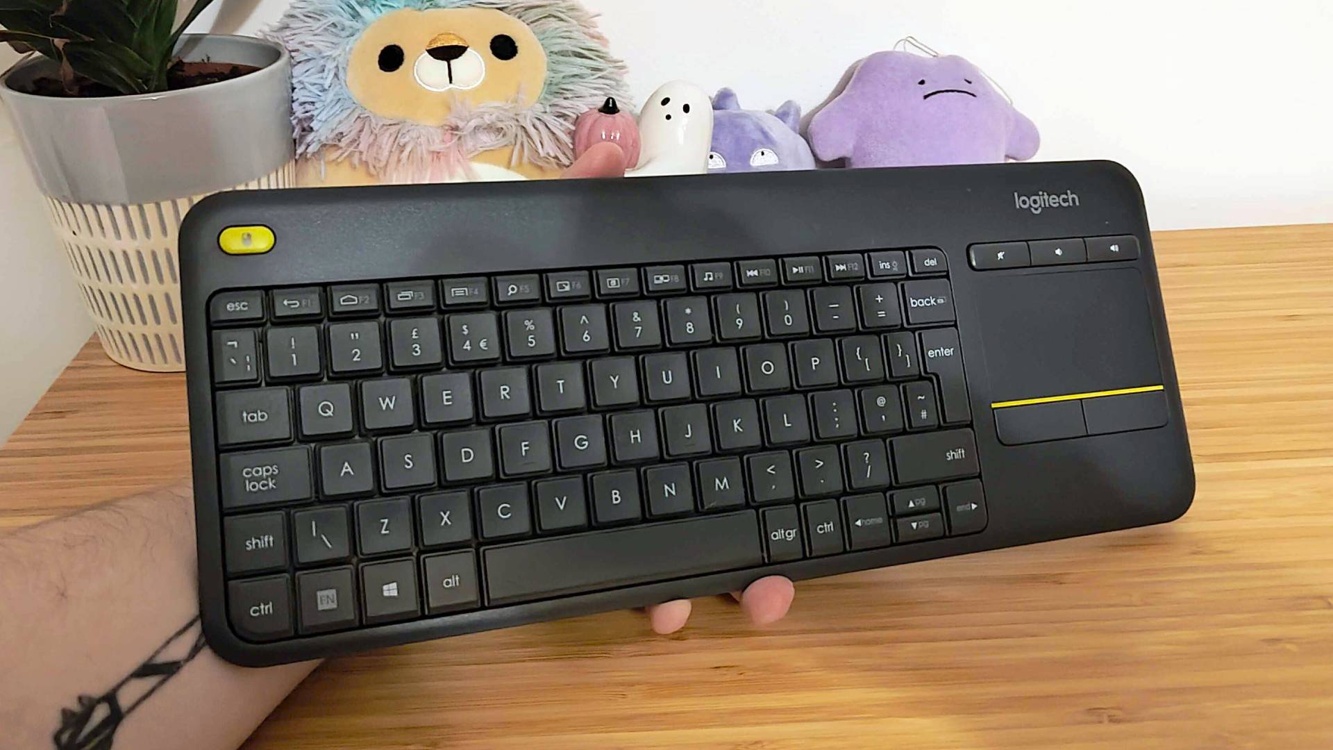 Hand holding Logitech K400 Plus keyboard