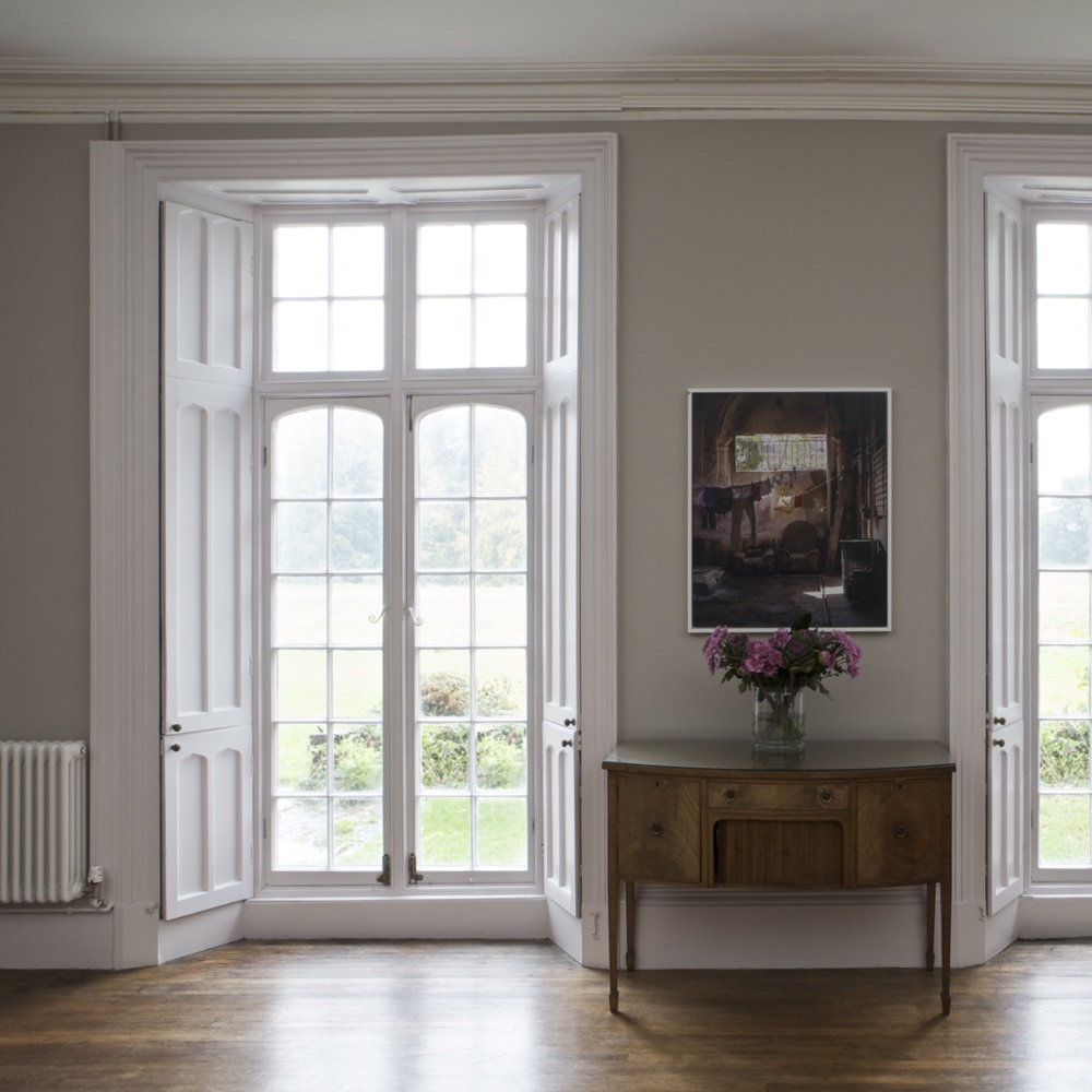 wooden floor with french door and teal colour wall