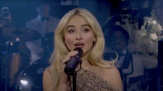 Sabrina Carpenter performing in sparkly dress at SNL 50.
