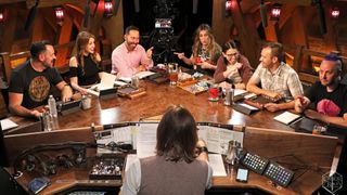 The cast of Critical Role, sat around the iconic table