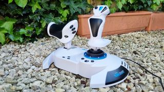 The Thrustmaster T.Flight HOTAS One Microsoft Flight Simulator Edition on white gravel with foliage in the background